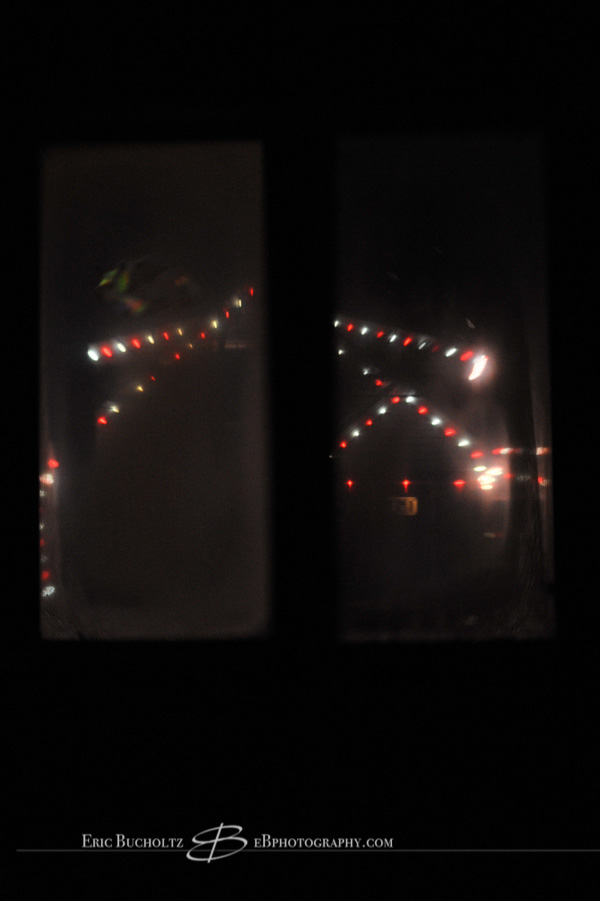 Lensbaby tilt shift manual focus lens image, red and white Christmas lights through window